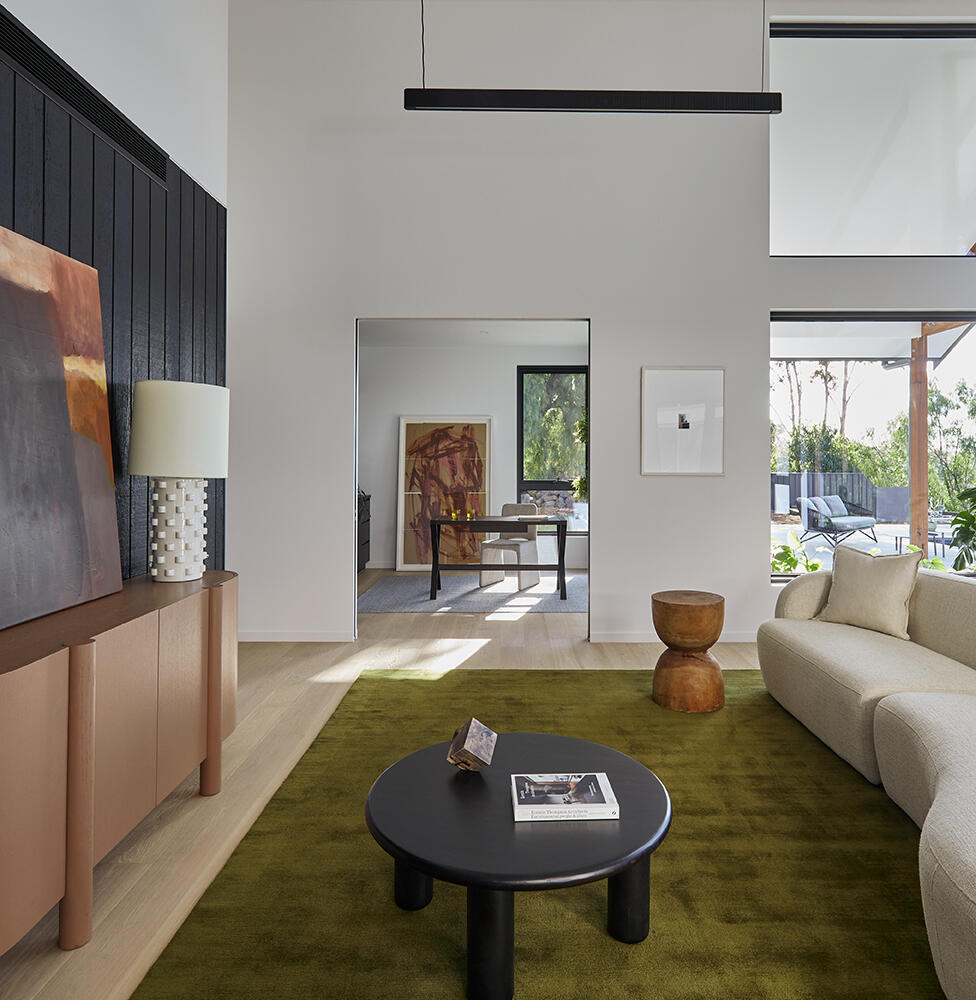 Modern High-End Living Area By Fox Building Group Featuring A Black Timber Feature Wall, Double-Height Ceilings, And Expansive Architectural Glazing.