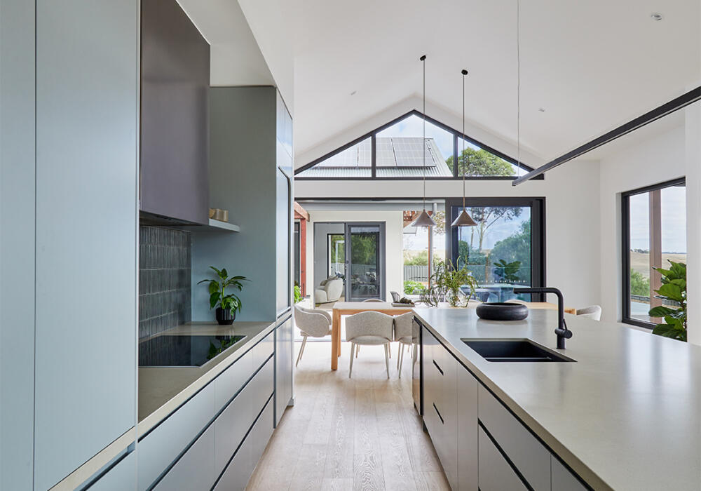 Modern Architectural Kitchen And Living Area By Fox Building Group Featuring A Vaulted Ceiling, Gable Window, And Sleek Contemporary Joinery.