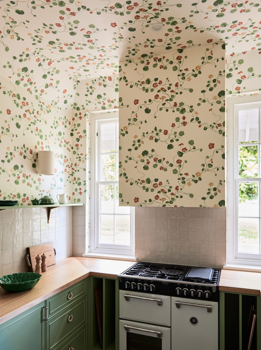 A Bespoke Kitchenette Featuring Green Shaker-Style Cabinetry, Timber Benchtops, And Floral Lake August ‘Nasturtium’ Wallpaper That Wraps Around The Range Hood.