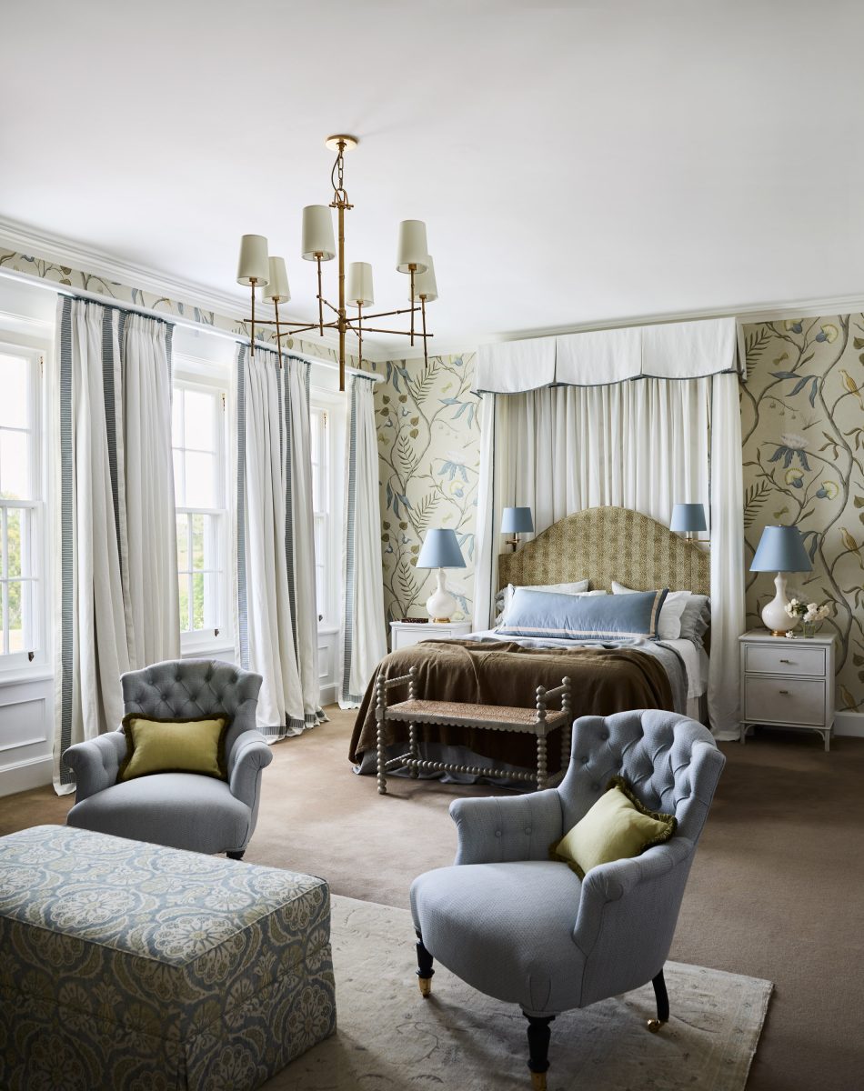 A Grand Bedroom With Lewis And Wood Adam&Apos;S Eden Botanical Wallpaper, A High Canopy Bed With White Valance, And Two Light Blue Tufted Armchairs In The Foreground.