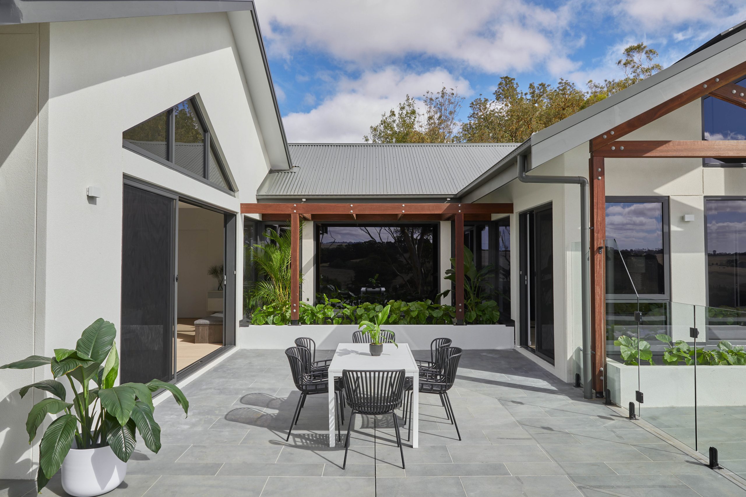 Stained Timber Pergola With Exposed Rafters Wrapping The Home&Apos;S Courtyard