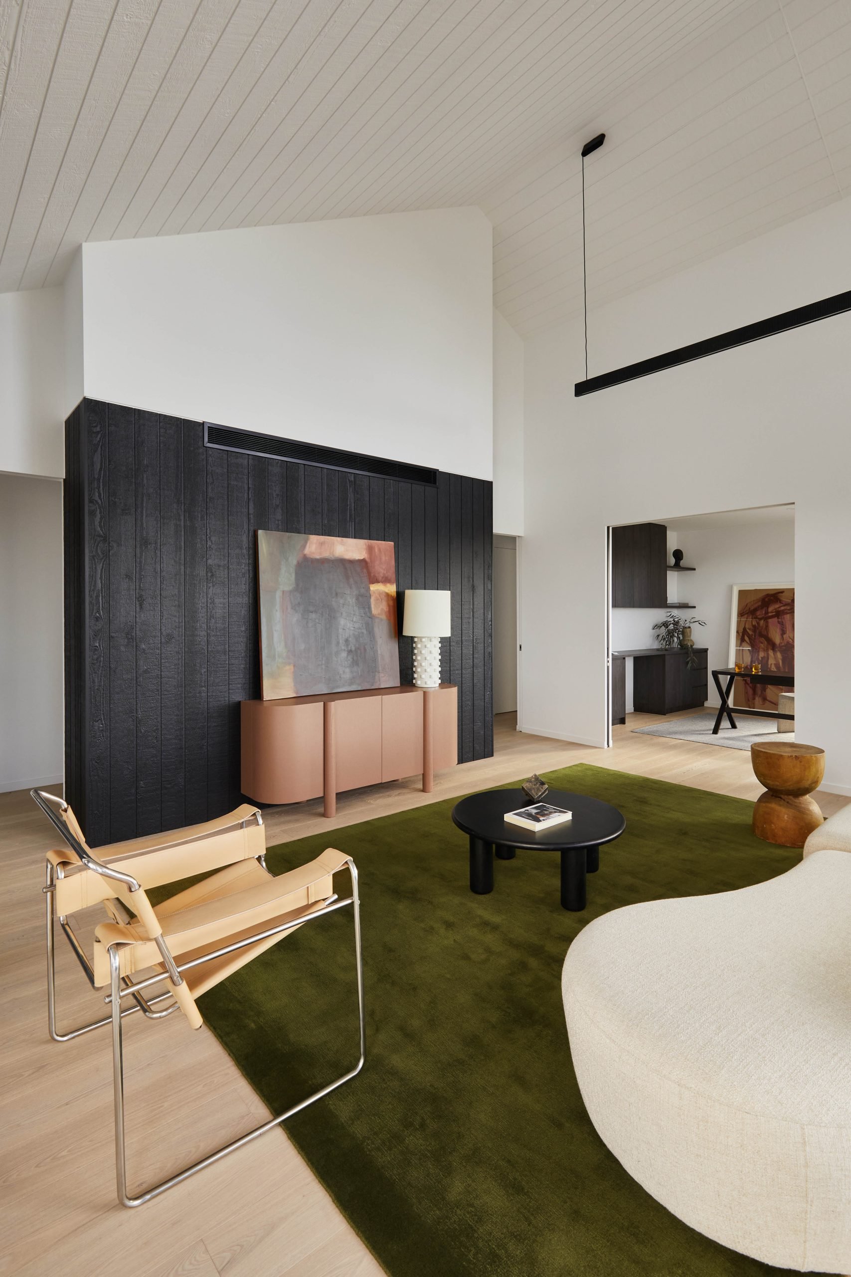 Living Room With Raked Timber-Lined Ceiling And Exposed Structural Timber Trusses