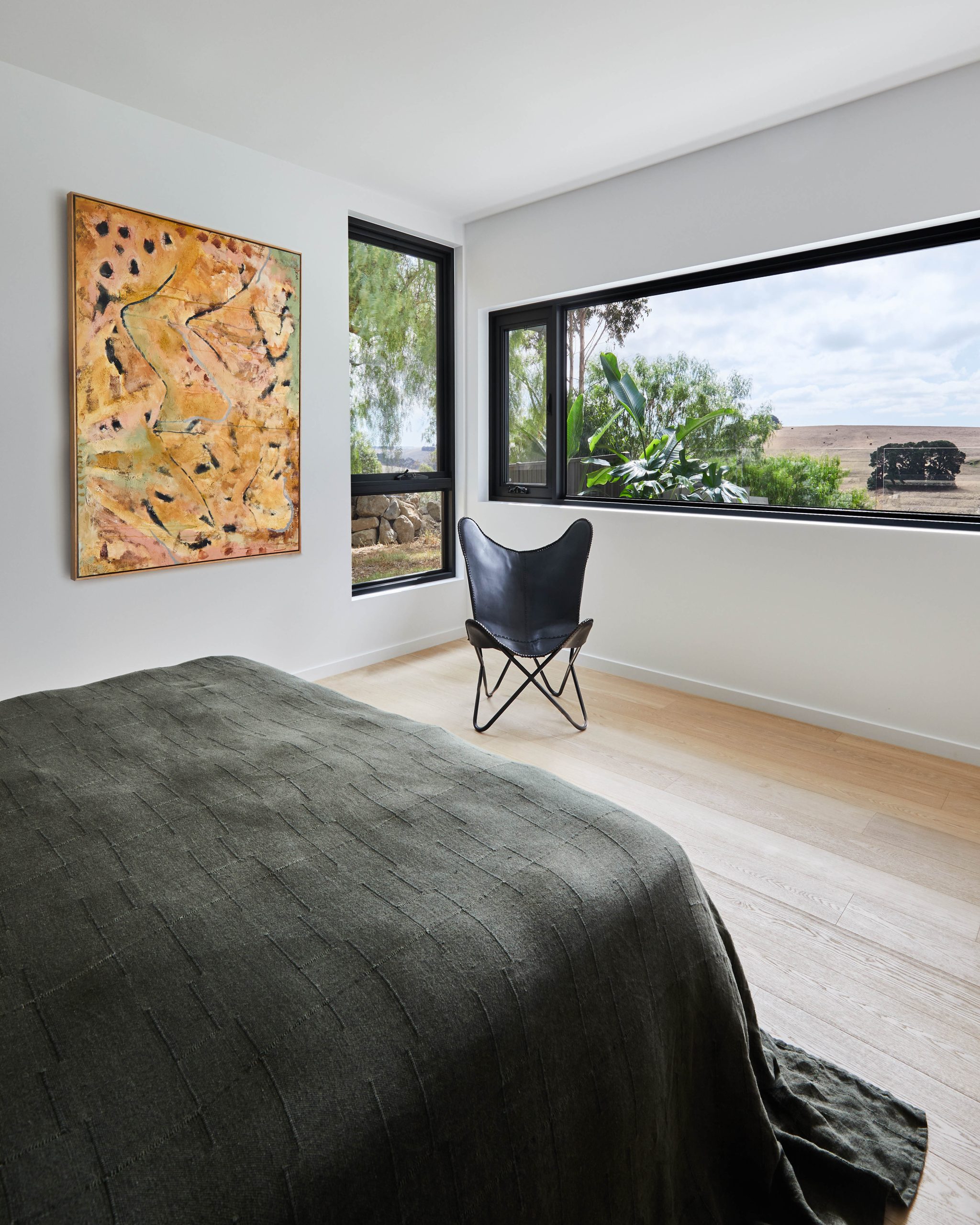 Main Bedroom Bed Styled With Artwork And A Window Seat Outlook To The Garden