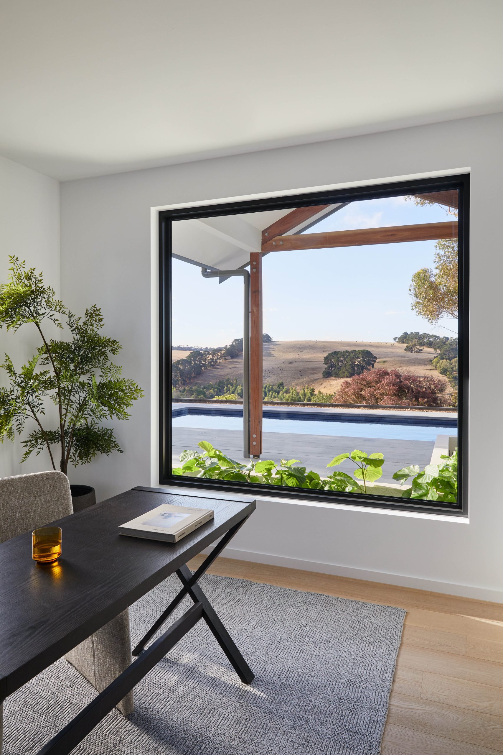 Home Office Desk Beneath A Picture Window Framing The Pool And Paddock View