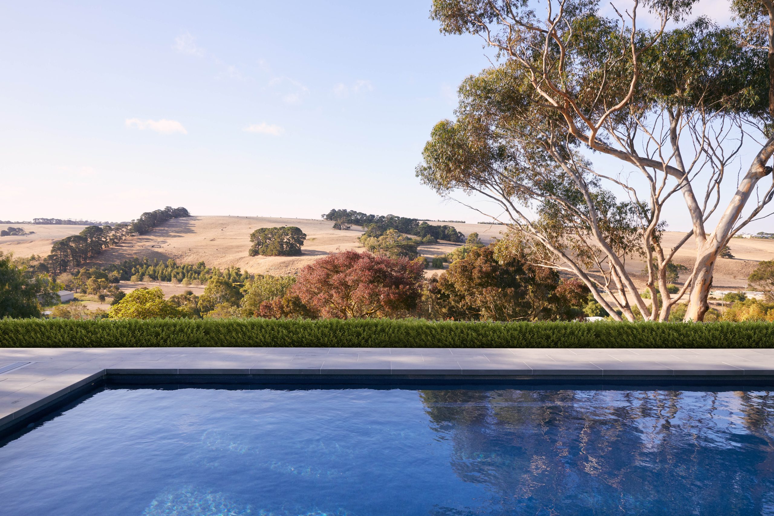 Swimming Pool At Dusk Reflecting The Evening Sky Beside The Home