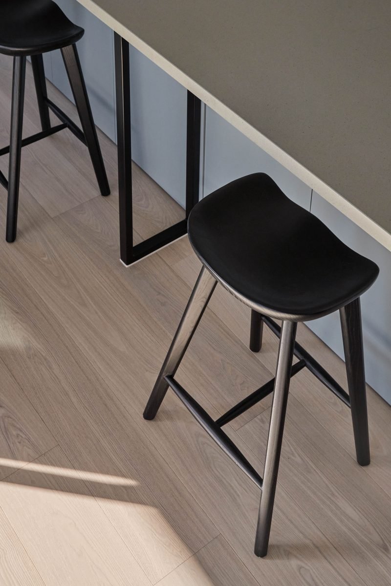 Upholstered Dining Chairs Beside Integrated Wine Storage In The Kitchen Island