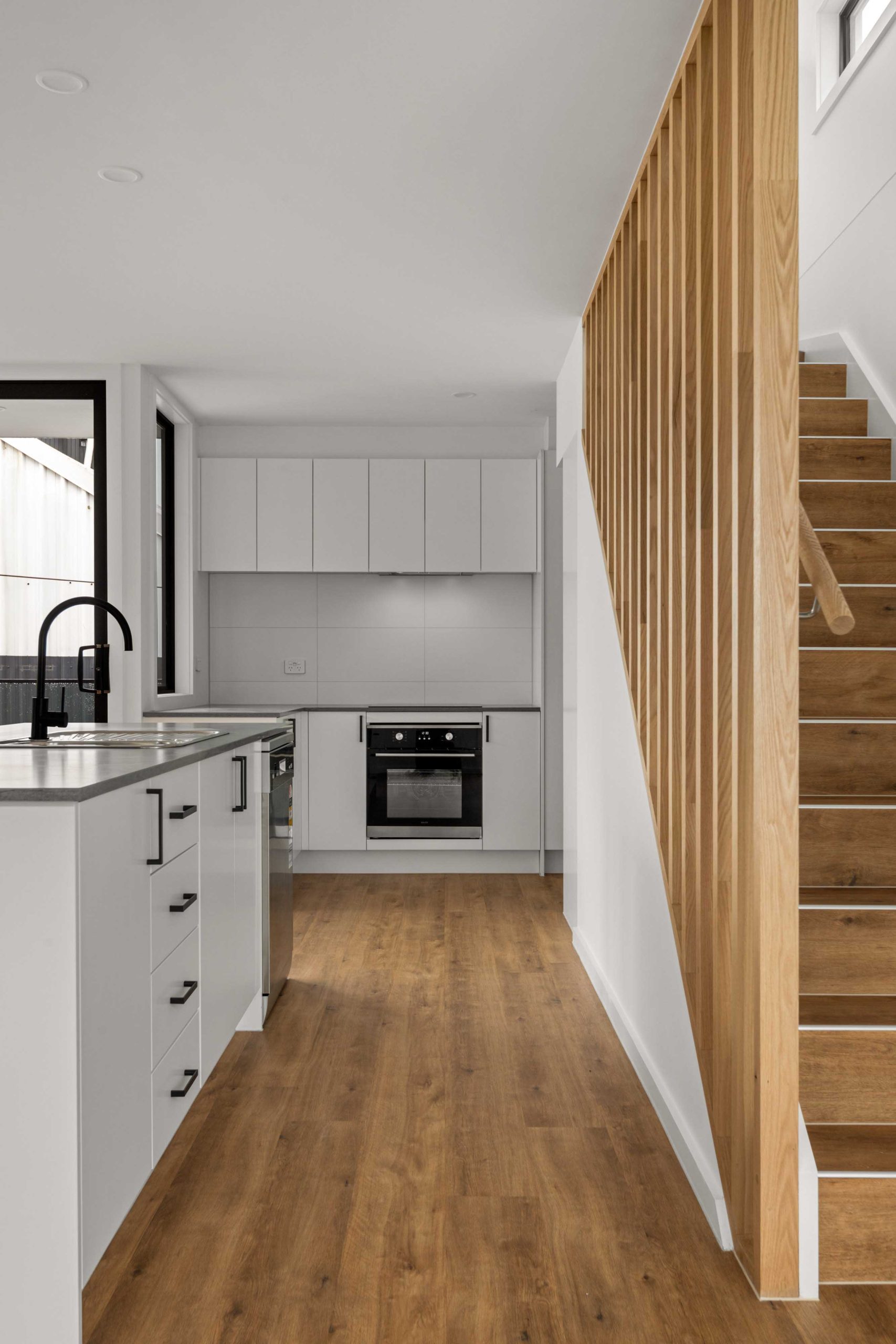 Townhouse Development South Geelong – Wide View Of Open-Plan Kitchen, Living Area And Timber-Slat Staircase Void