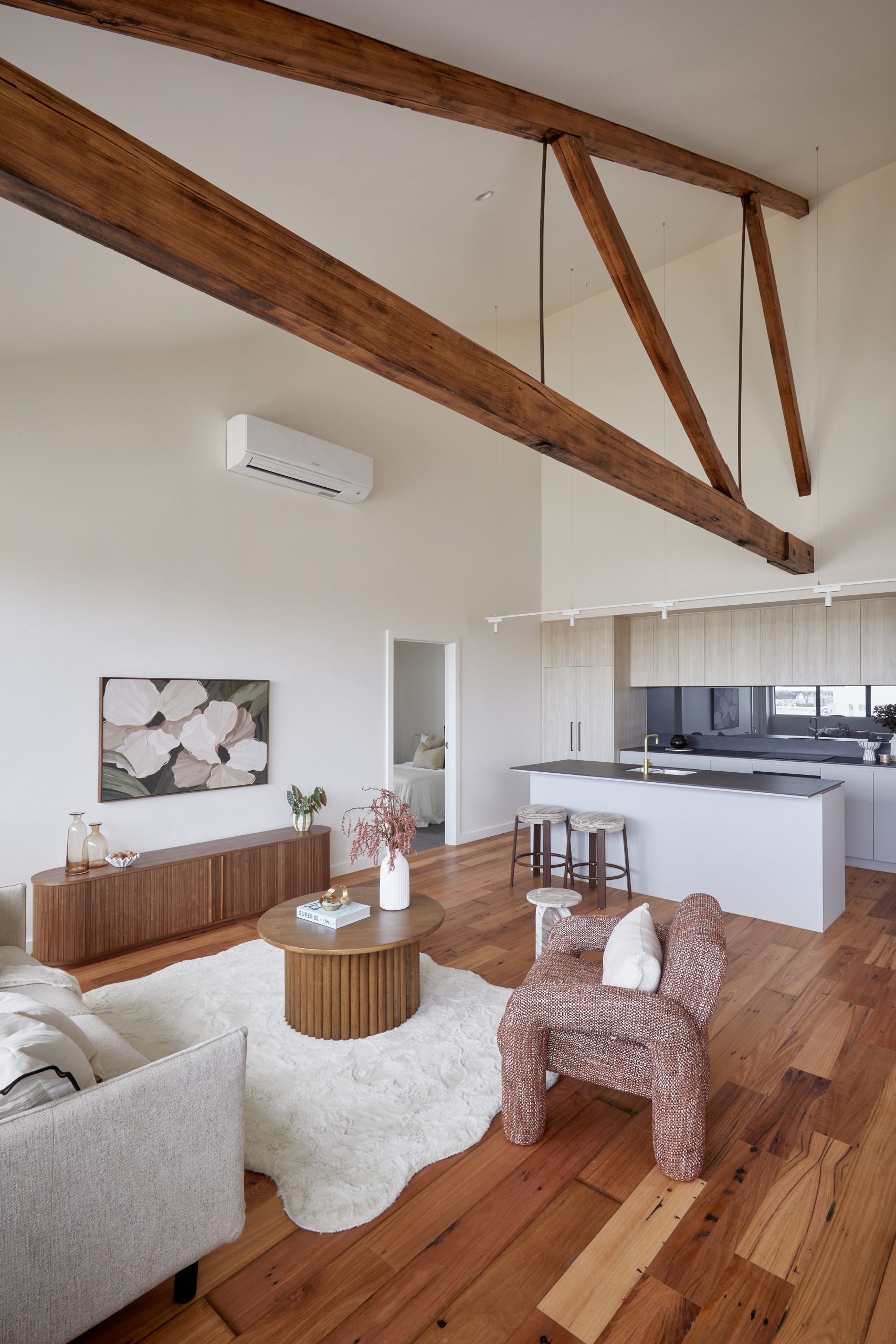 Open-Plan Apartment Living Room Featuring Exposed Original 1920S Oregon Timber Trusses, Columns, And Recycled Hardwood Floorboards.