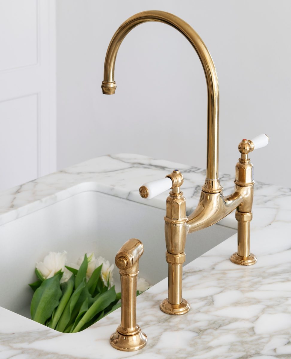 Antique Brass Bridge Mixer Tap Over A White Farmhouse Sink On Carrara Marble Benchtop In The Award-Winning Carlton Renovation By Fox Building Group.