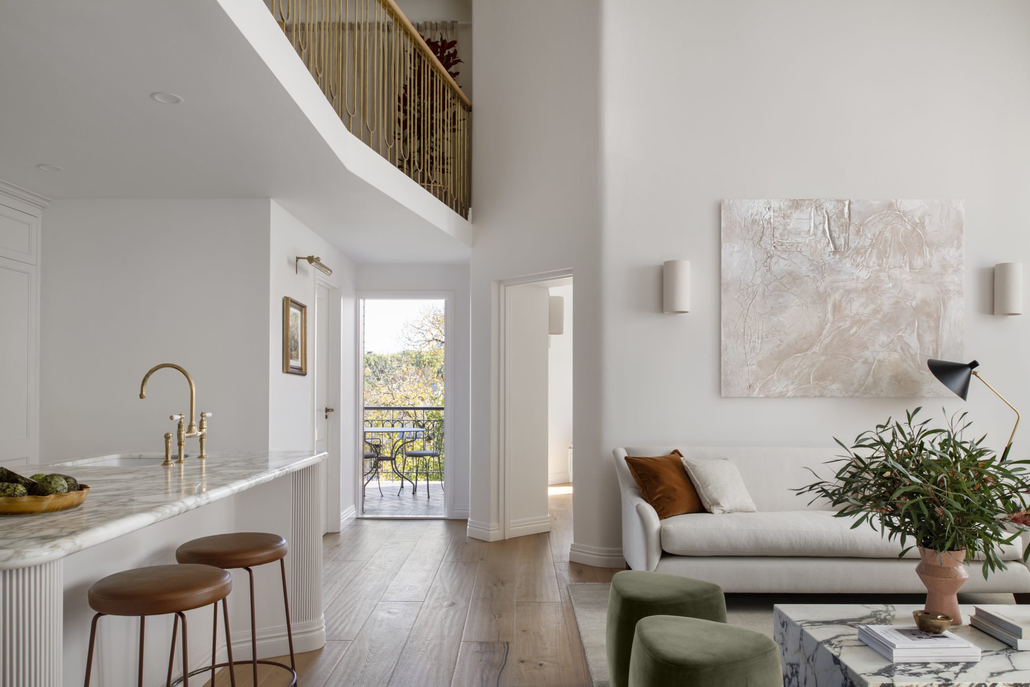 Open-plan kitchen, hallway and double-height living room with mezzanine library in the award-winning Carlton Renovation by Fox Building Group.