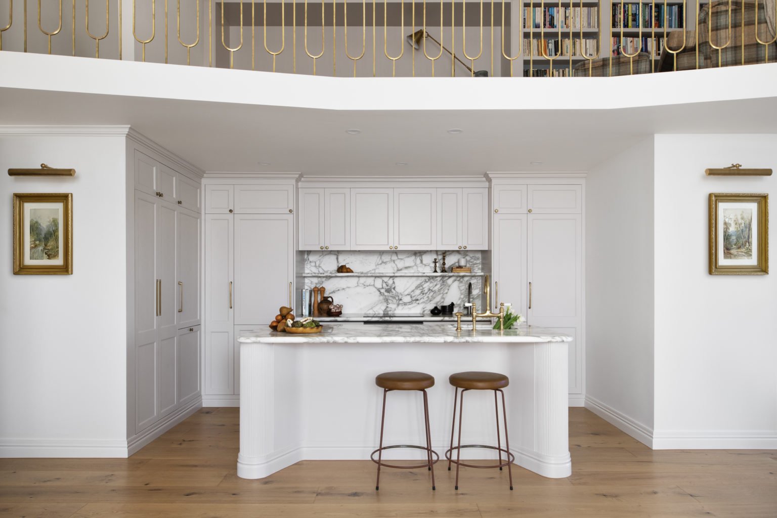 Double-Height Kitchen With A Brass-Balustraded Mezzanine Library And Gilt-Framed Artwork In The Award-Winning Carlton Renovation By Fox Building Group.