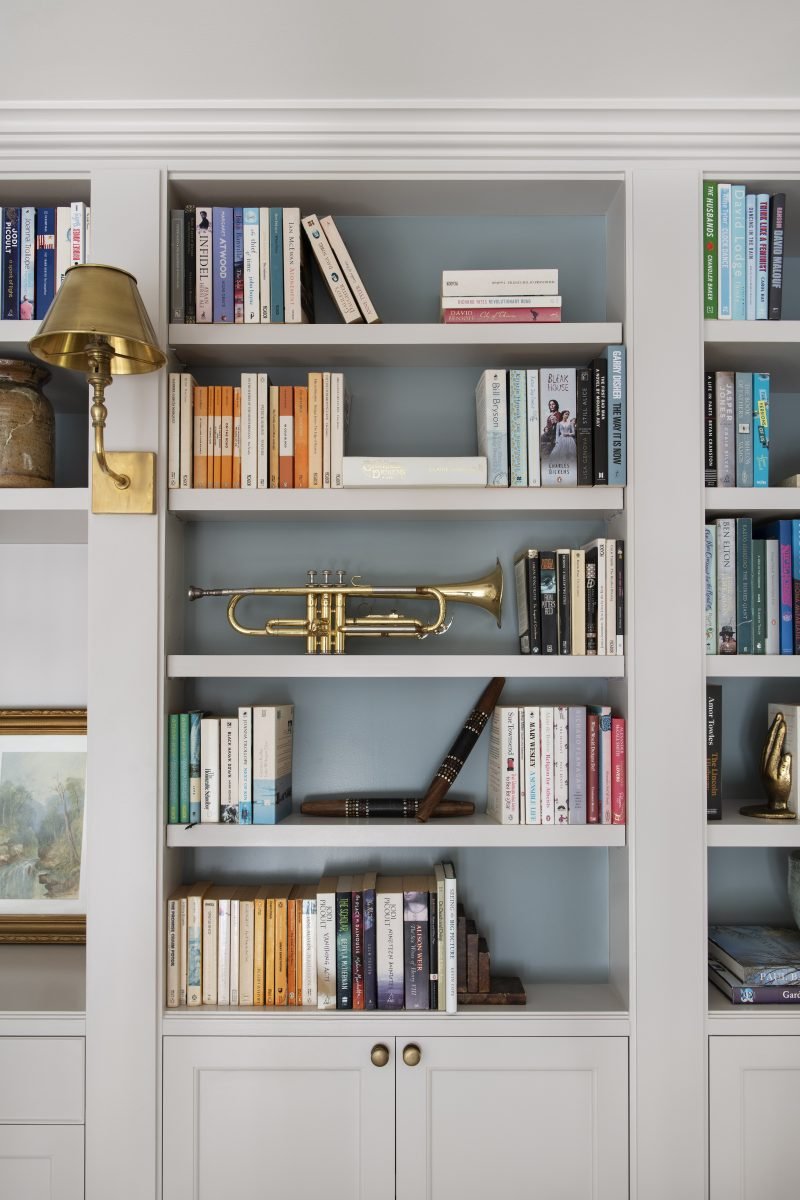 Built-In Bookshelf Joinery With A Brass Reading Light And Trumpet Display In The Mezzanine Library Of The Award-Winning Carlton Renovation By Fox Building Group.