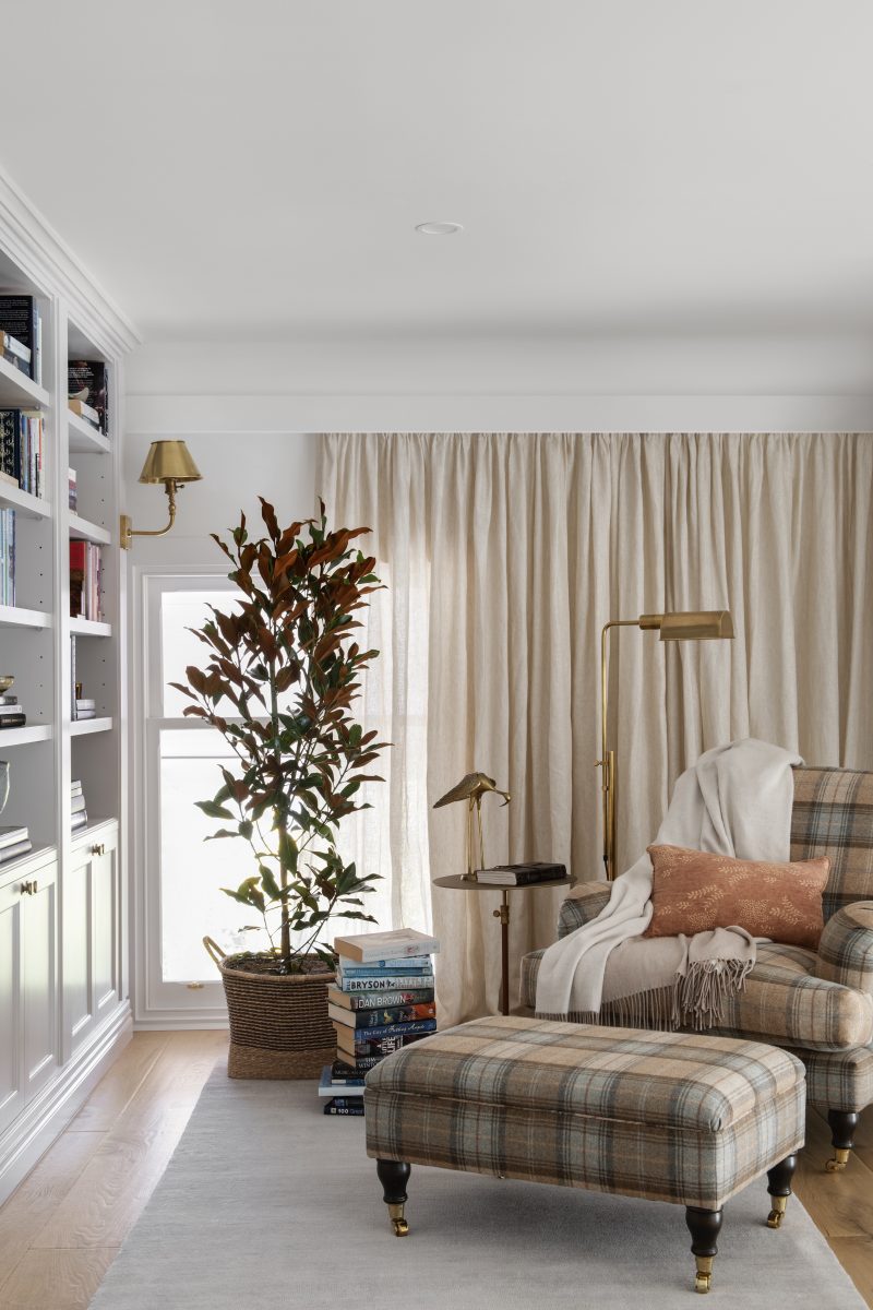 Tartan Armchair And Ottoman Beside A Linen-Curtained Window In The Mezzanine Reading Nook Of The Award-Winning Carlton Renovation By Fox Building Group.