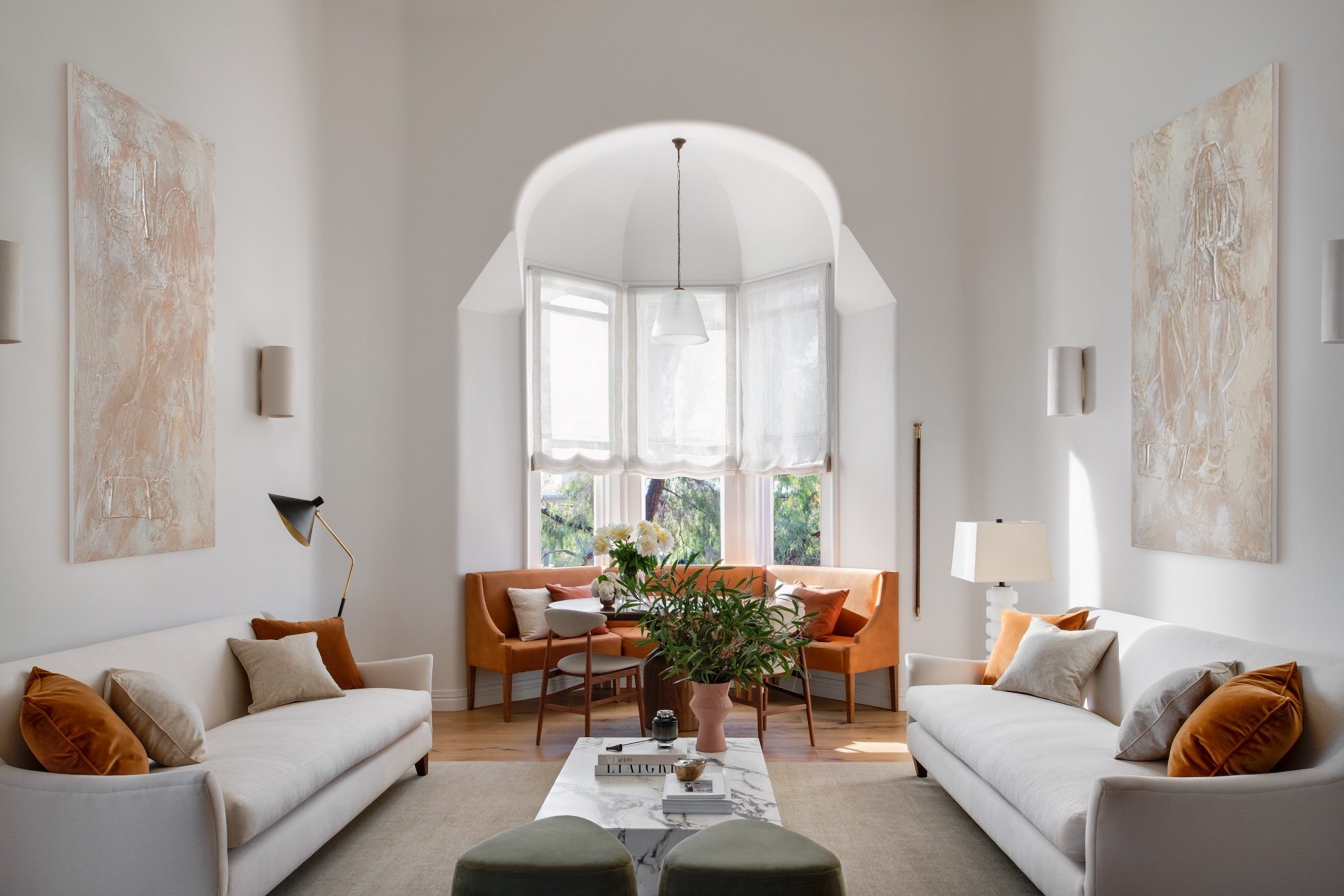 Symmetrical Living Room With Twin Cream Sofas Either Side Of A Barrel-Vaulted Bay Window Banquette In The Award-Winning Carlton Renovation By Fox Building Group.