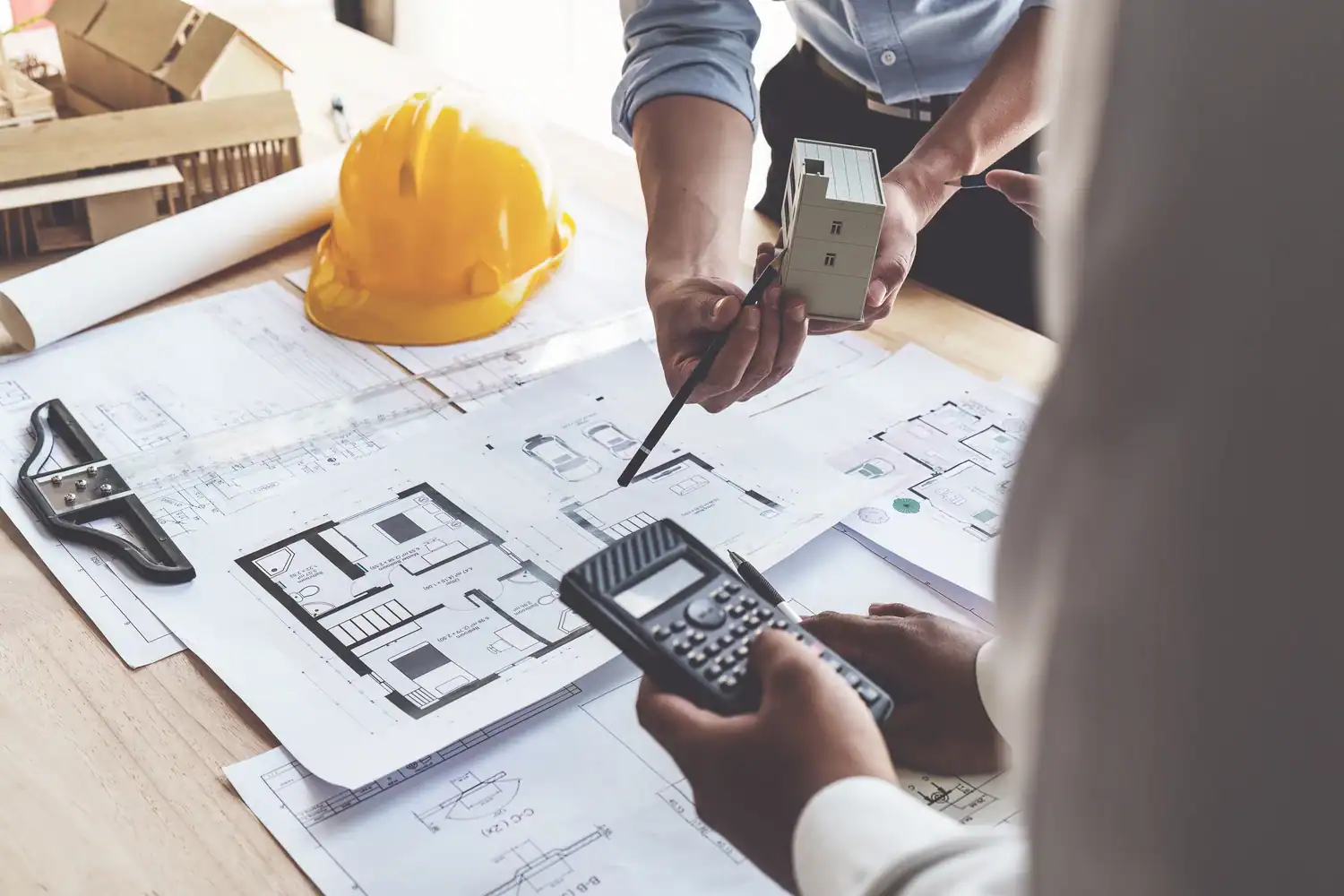 Architect and quantity surveyor reviewing a commercial cost plan against building plans